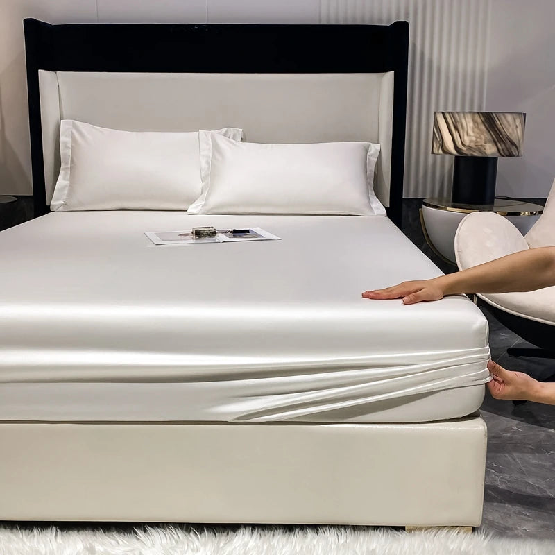 Person adjusting a fitted sheet on a bed in a bedroom setting.