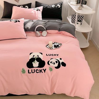 Pink bedding set with panda design and 'LUCKY' text on a bed in a room.