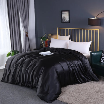 Modern bedroom with a gold bed frame, black comforter, and gray walls.