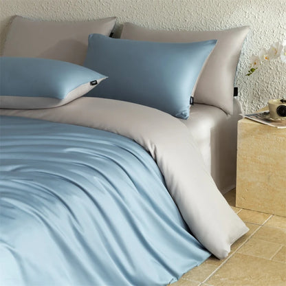 Bed with light blue bedding and pillows in a bedroom setting.