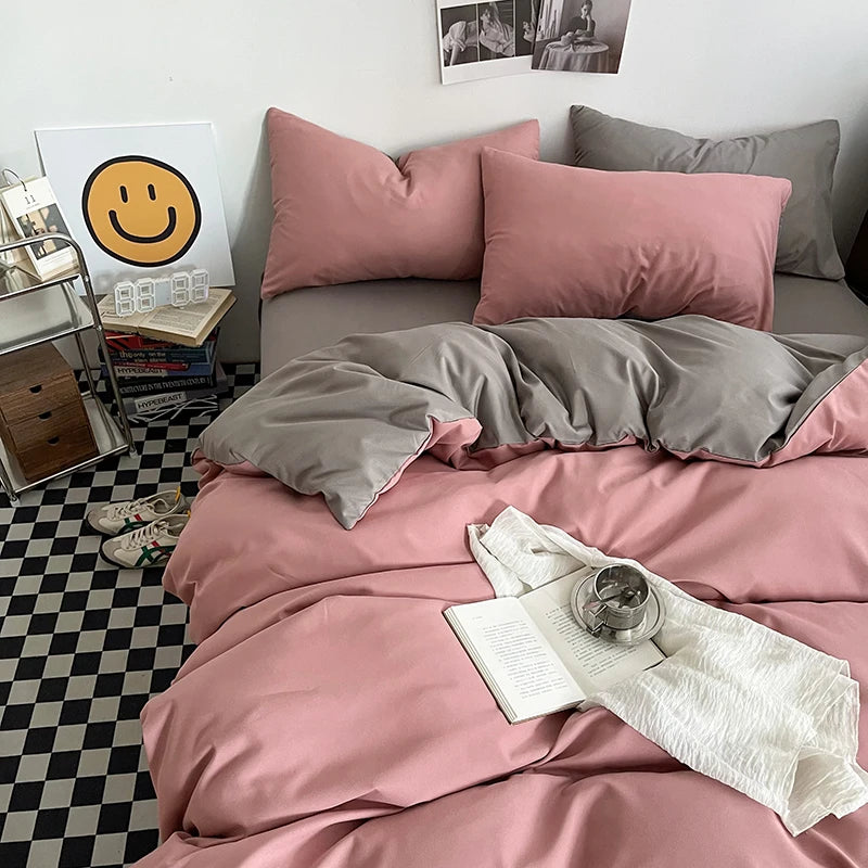 Bed with pink and gray bedding, books, and a smiley face poster on a checkered floor.
