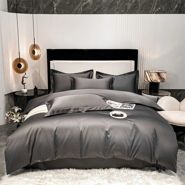 Gray bedding set on a bed in a modern bedroom with marble walls and decorative lamps.