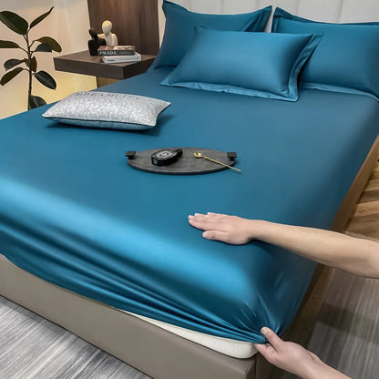 Person adjusting a blue satin sheet on a bed with a hand reaching in.
