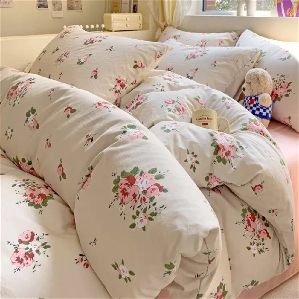 Floral patterned bedding set on a bed with a teddy bear toy.