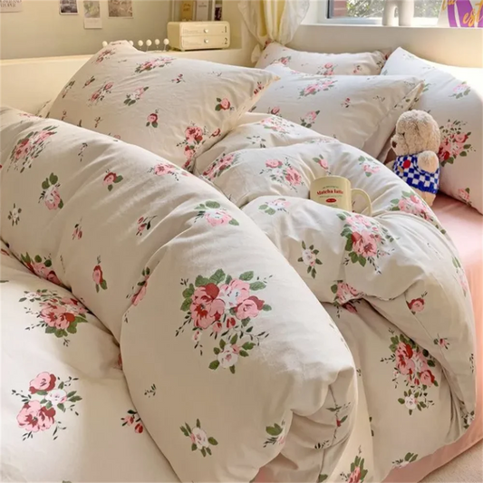 Floral patterned bedding set on a bed with a teddy bear toy.