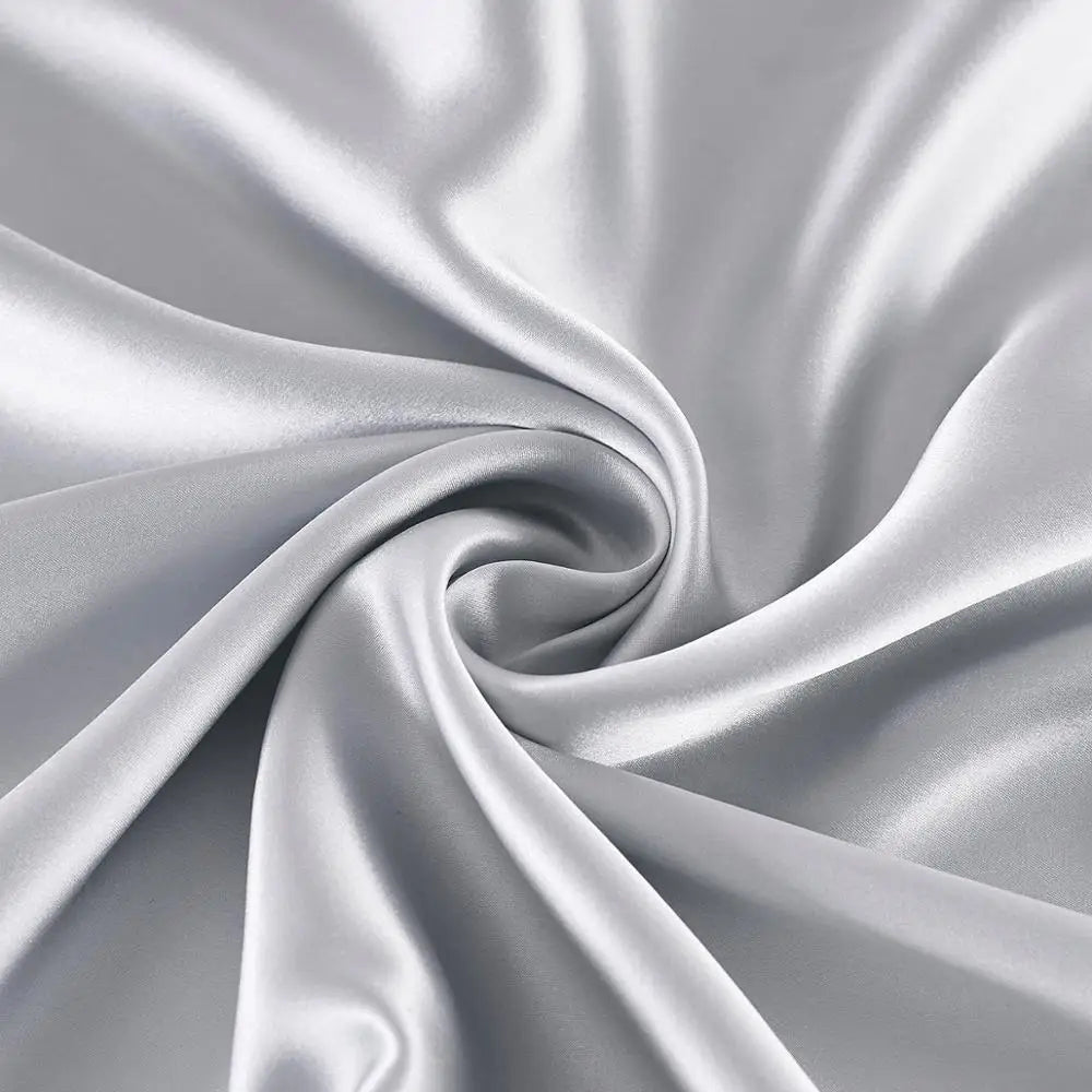 Close-up of silver satin fabric with folds