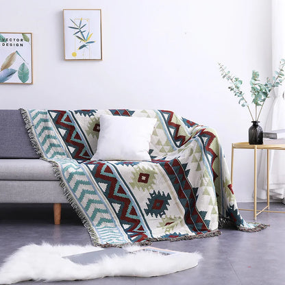 Geometric patterned blanket draped over a sofa in a living room setting.