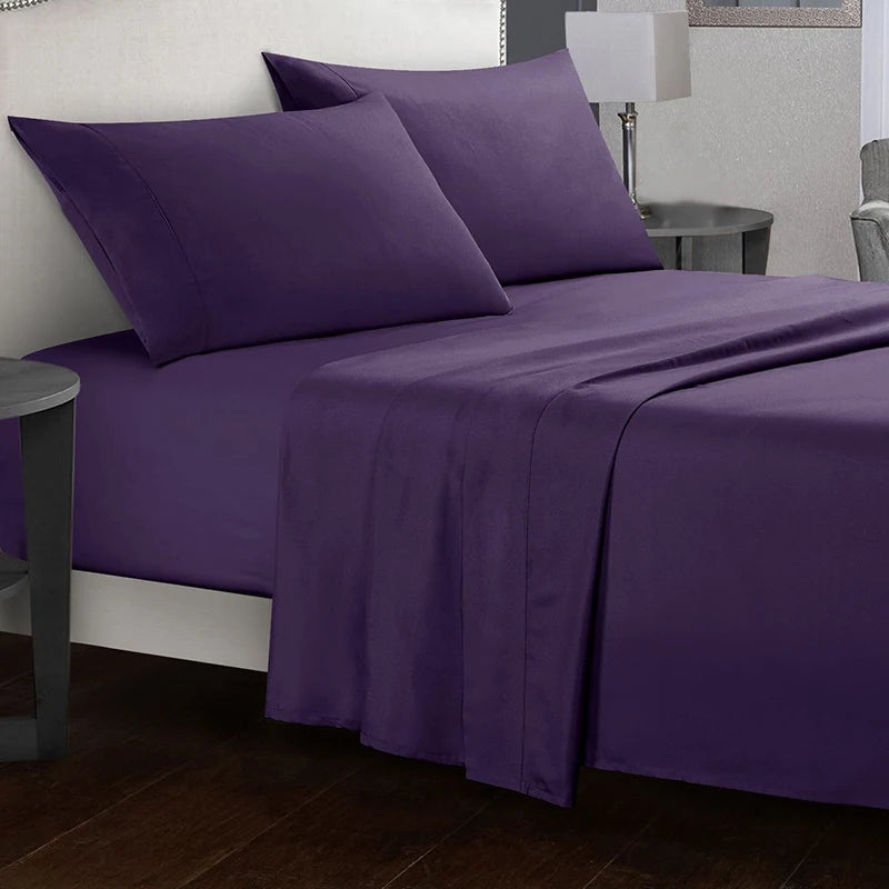 Purple bed sheets and pillows on a bed in a bedroom setting.