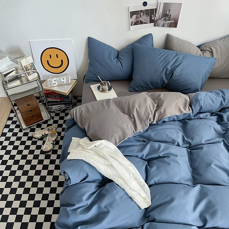 Bedroom with blue bedding and gray pillows on a checkered floor.