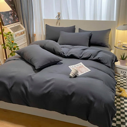 Gray bedding set on a bed with a magazine in a bedroom setting.
