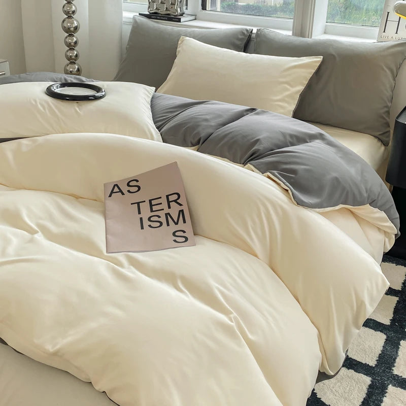 Beige comforter and pillows on a bed with a book titled 'AS TERRORISM' in a bedroom setting.