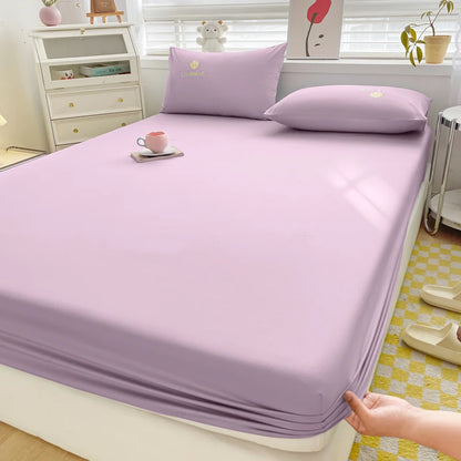 Purple bed sheet set on a bed in a room with a dresser and decor items.