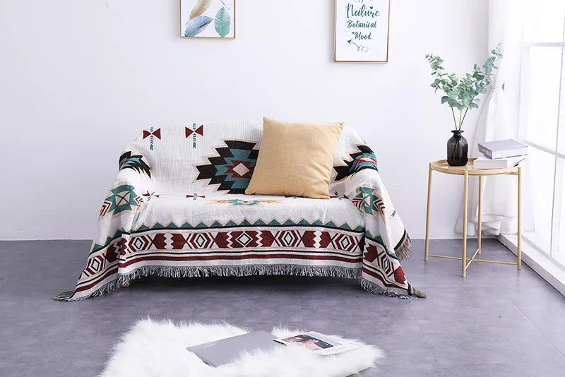Sofa with a patterned throw blanket and pillow in a living room setting.