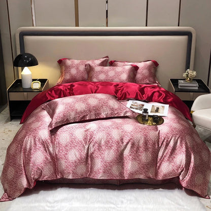 Bed with red and pink patterned bedding in a bedroom setting.