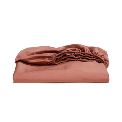 Folded terracotta-colored fitted sheet on a white background