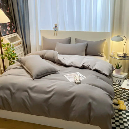 Gray bedding set on a bed in a bedroom with decor elements.