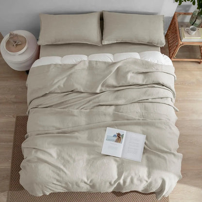 Beige bedding set on a bed with a nightstand in the background