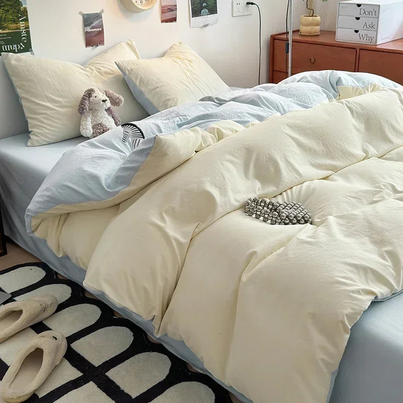 Neatly made bed with beige comforter and pillows in a bedroom setting.