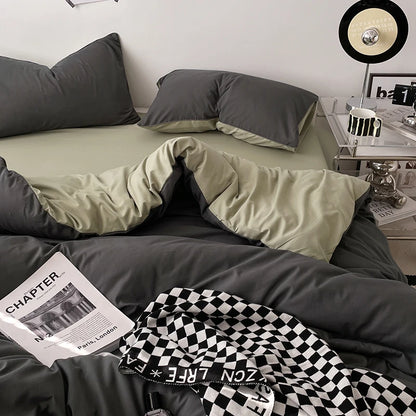 Bed with gray and green bedding, checkered blanket, and newspaper on a nightstand.