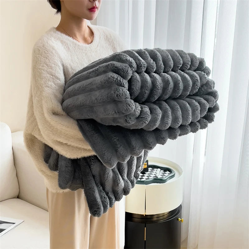 Person holding a large gray blanket in a living room setting