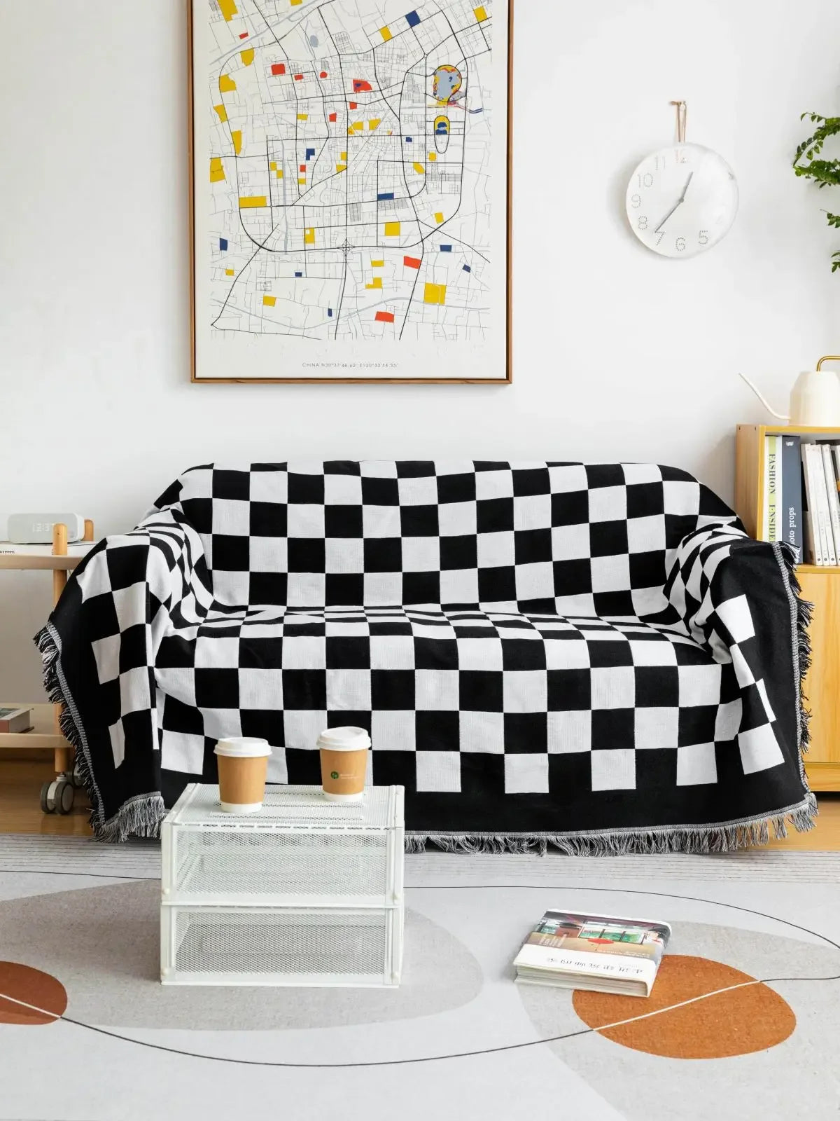 Black and white checkered throw blanket draped over a sofa in a living room.
