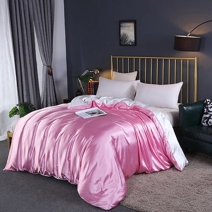 Bed with pink comforter and white pillows in a bedroom setting.