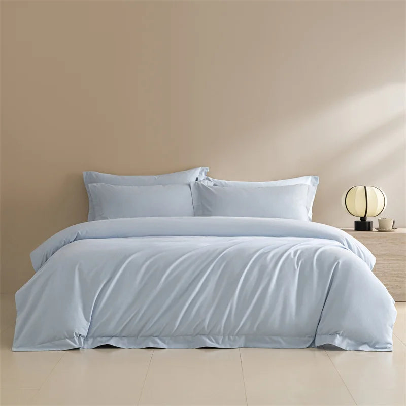 Light blue bedding set on a bed against a beige wall.
