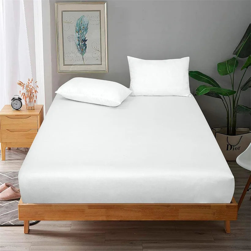 Bed with white mattress cover and pillows in a bedroom setting.