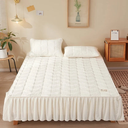 Bed with white quilt and pillows in a bedroom setting