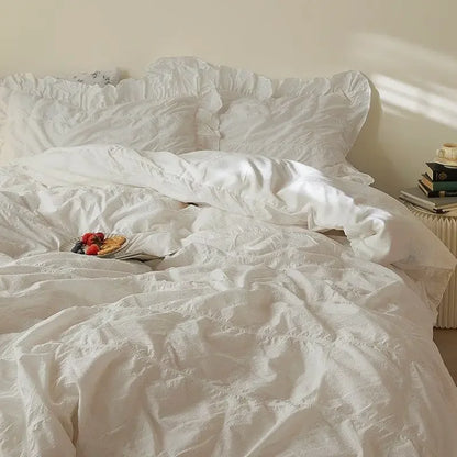 Unmade bed with white bedding in a softly lit room.