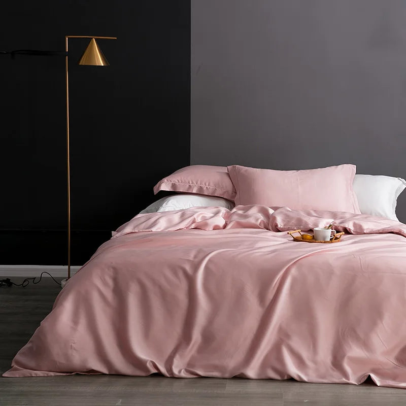 Pink bedding set on a bed in a room with a dark wall and floor lamp.