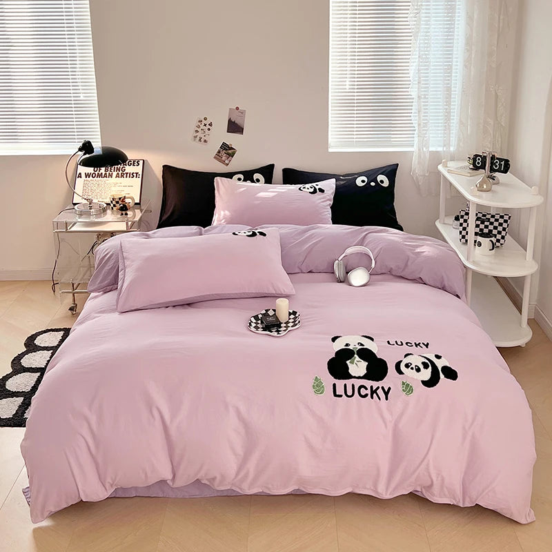 Pink bedding set with panda design on a bed in a room.