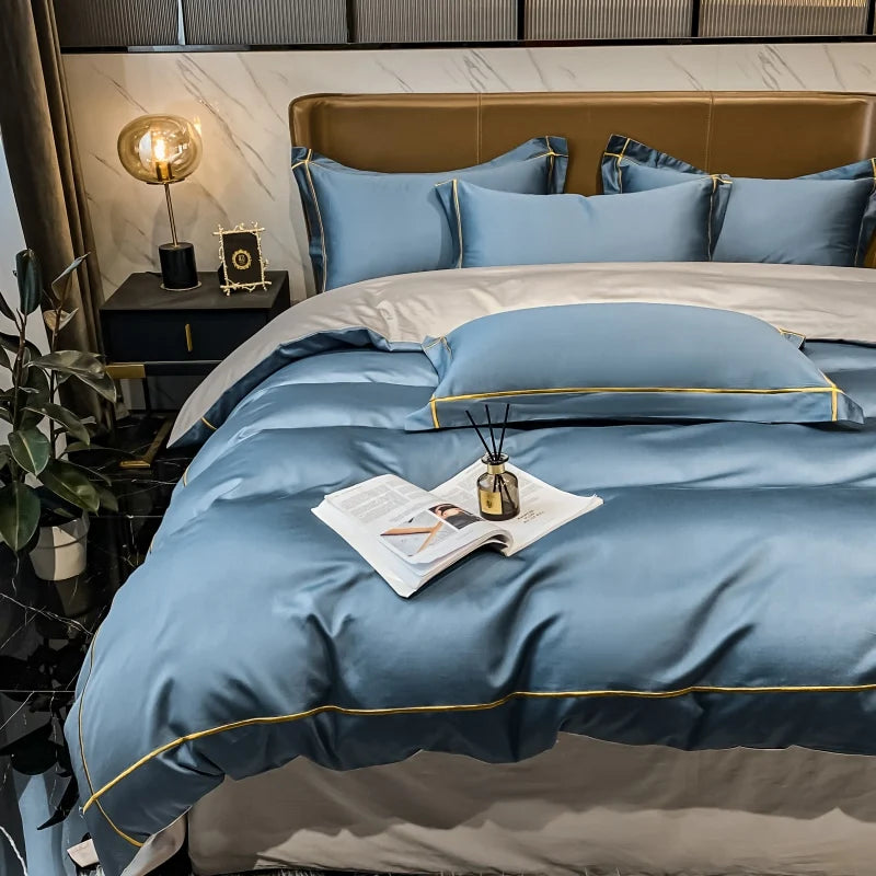 Blue bedding set on a bed with a nightstand and decorative items in a bedroom setting.