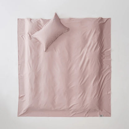 Pink satin sheet set with a pillow on a light gray background