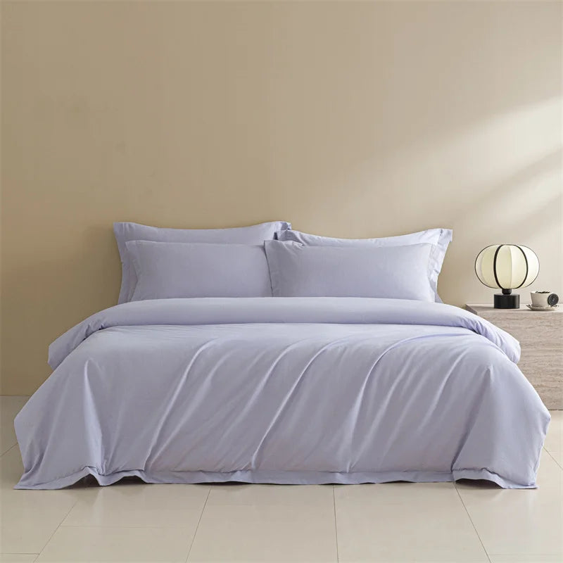 Light purple bedding set on a bed in a minimalistic bedroom.
