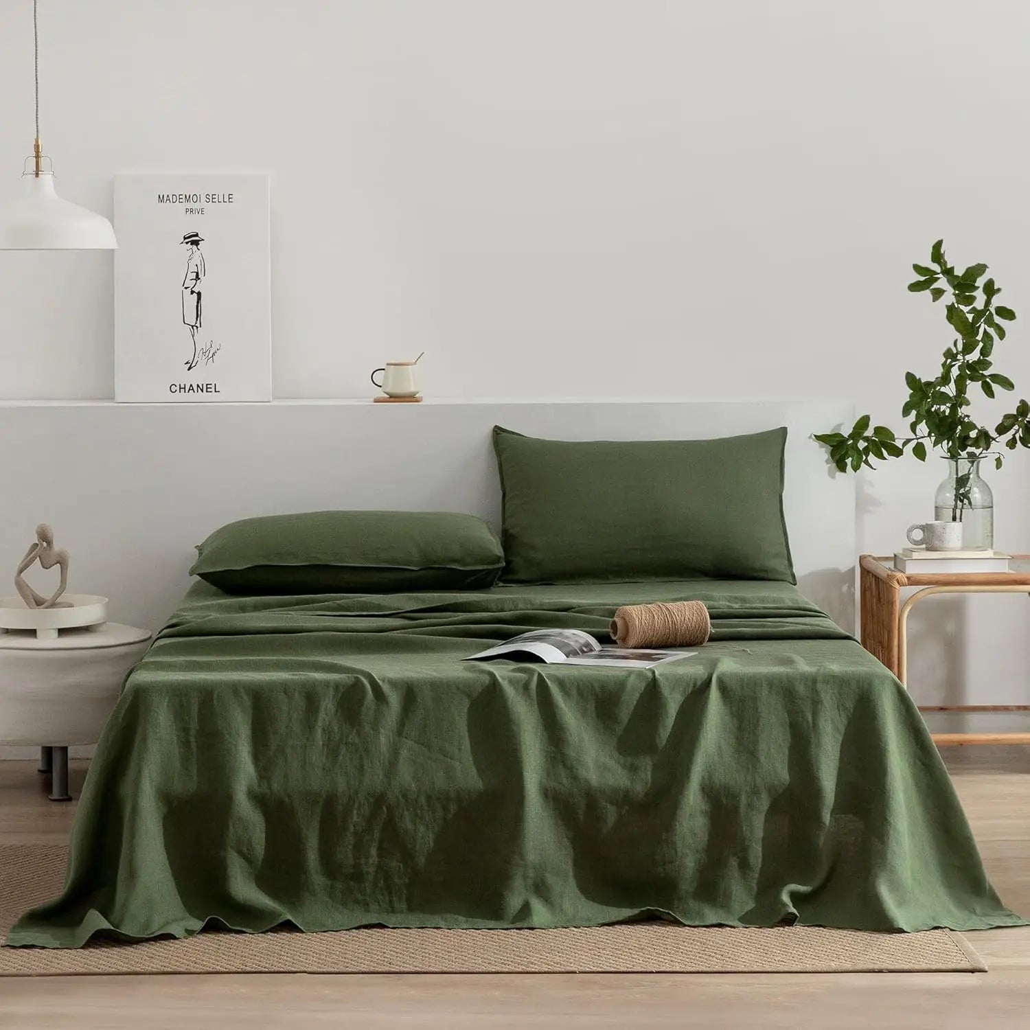 Green bedding set on a bed in a bedroom with a plant and decor items.