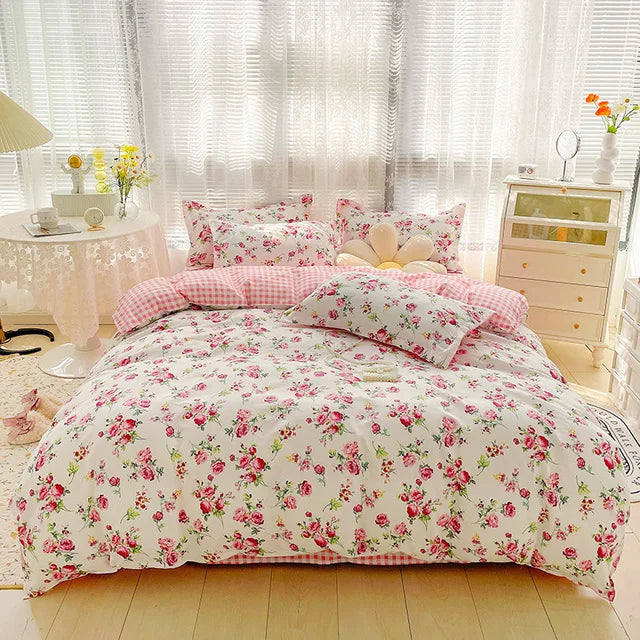 Floral bedding set on a bed in a bright bedroom with light-colored walls and furniture.