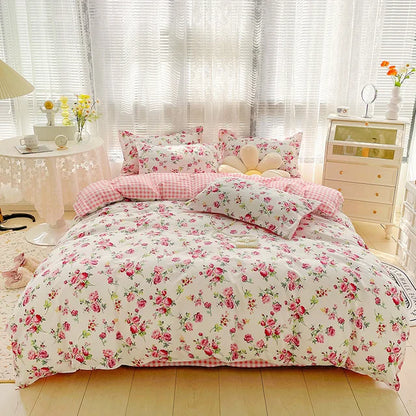 Floral bedding set on a bed in a bright bedroom with light-colored walls and furniture.