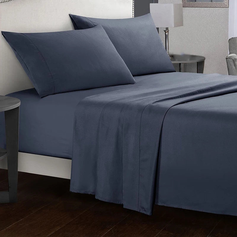 Blue bed sheets and pillows on a bed in a bedroom setting.