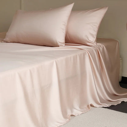Pink bedspread and pillows on a bed in a minimalistic room.