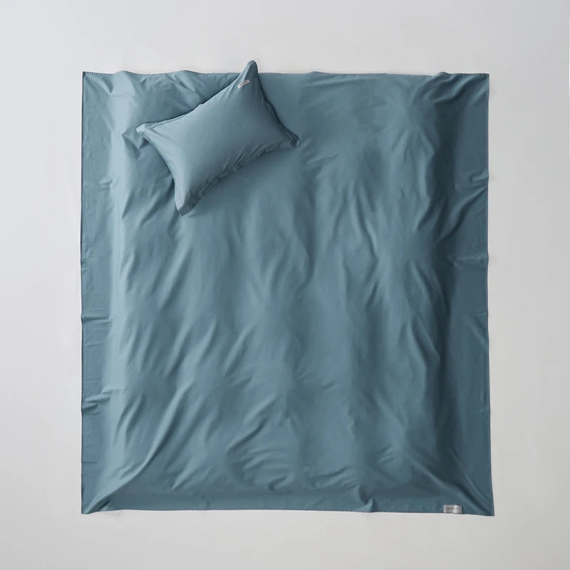 Blue bedding set with a pillow on a light gray background