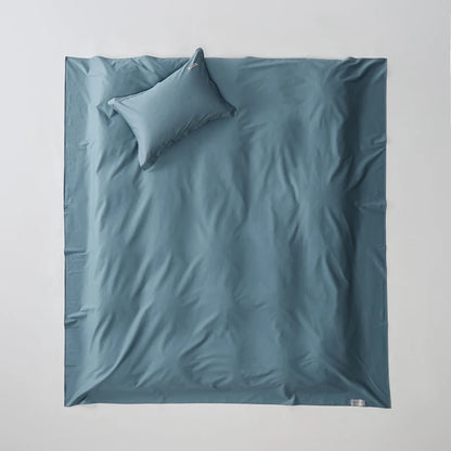Blue bedding set with a pillow on a light gray background