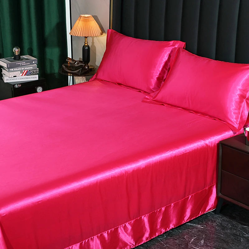Hot pink satin bedspread and pillowcases on a bed with a dark curtain background.