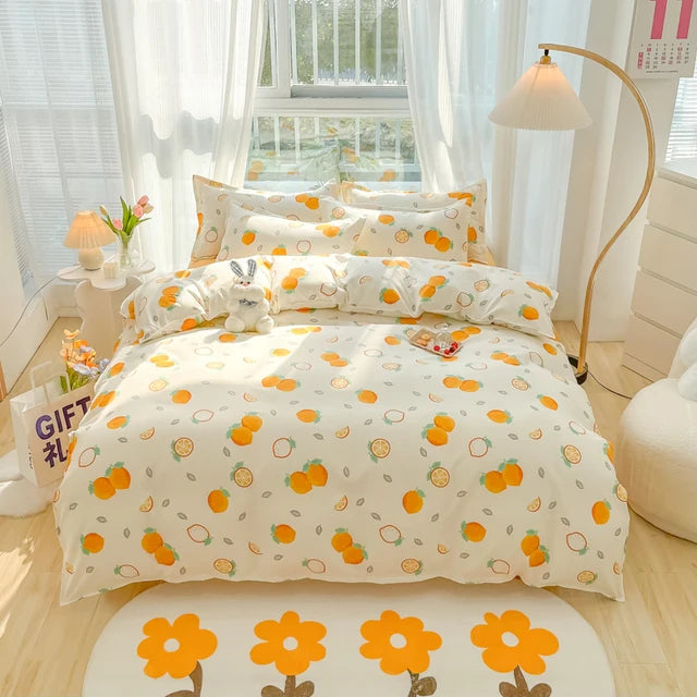 Bedding set with orange and green pattern on a bed in a bright room.