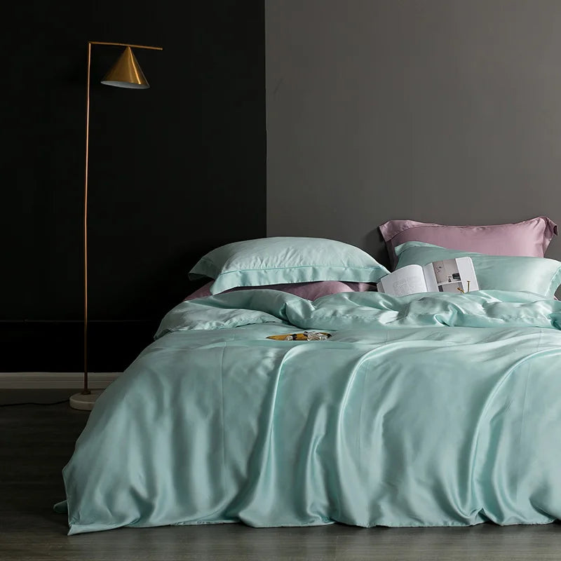 Bed with light blue bedding and pink pillows in a dimly lit room.