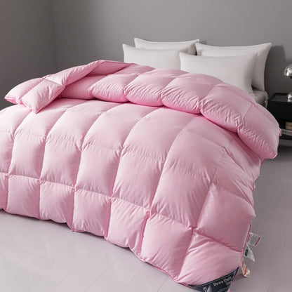 Pink quilt on a bed with white pillows in a bedroom setting