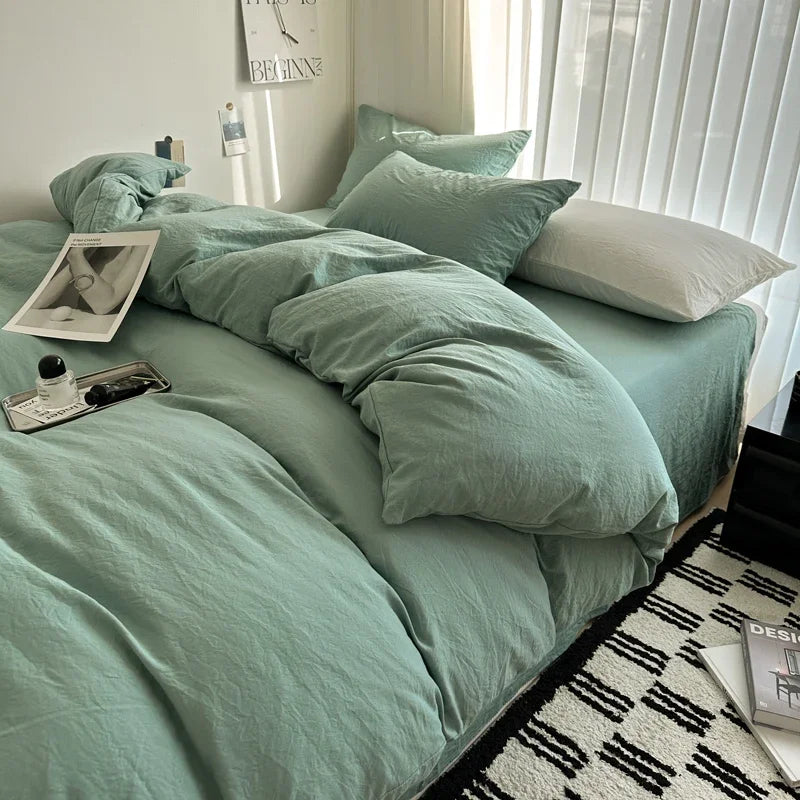 Bed with mint green bedding and white pillows in a well-lit room.