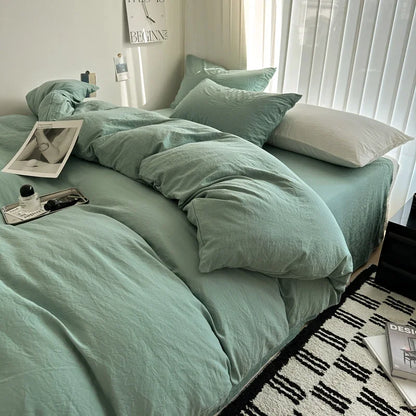 Bed with mint green bedding and white pillows in a well-lit room.