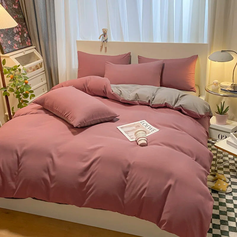 Pink bedding set on a bed in a bedroom with decor elements.