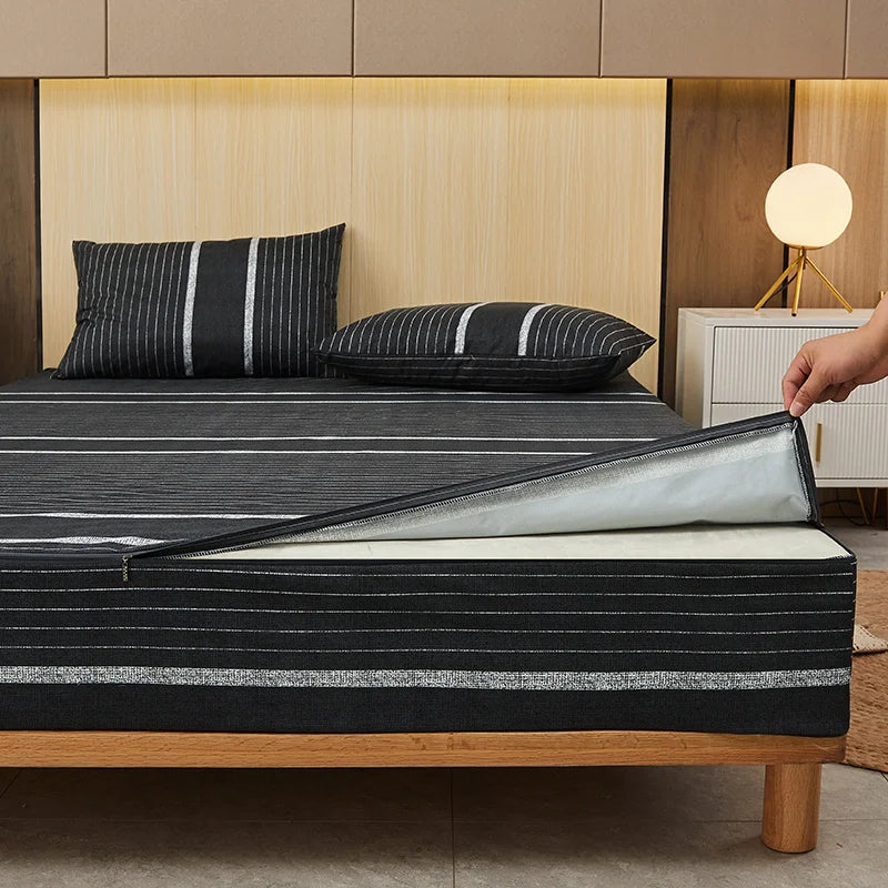 Person unrolling a black striped mattress cover on a bed with wooden headboard.